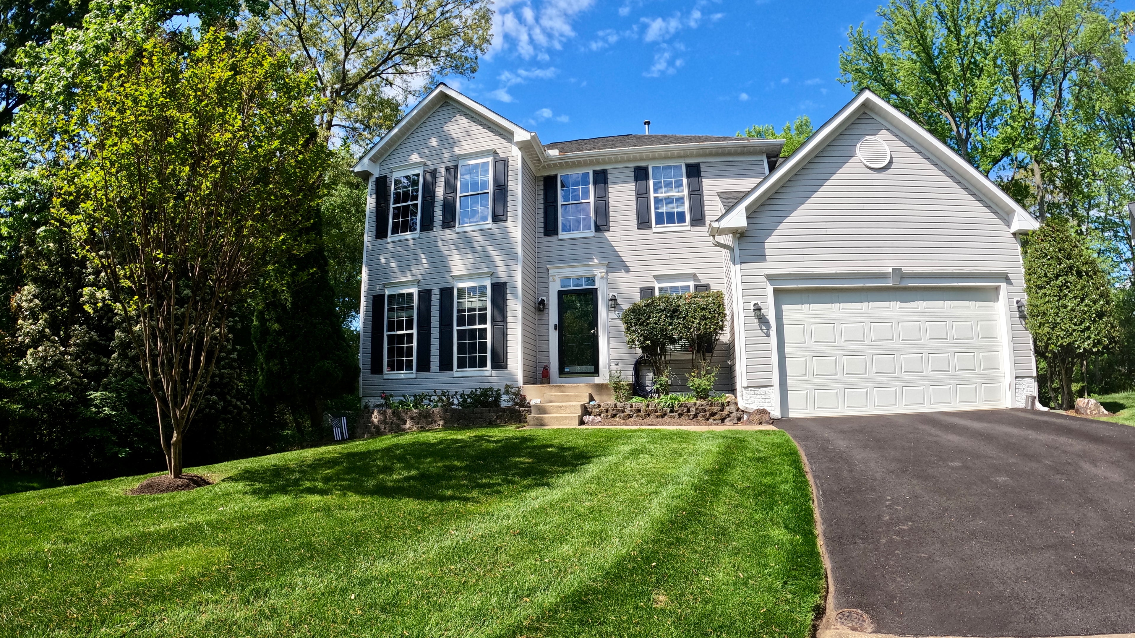 house with white siding and black shutters, surrounded by freshly cut grass at Cypress Ridge Dr, MD.