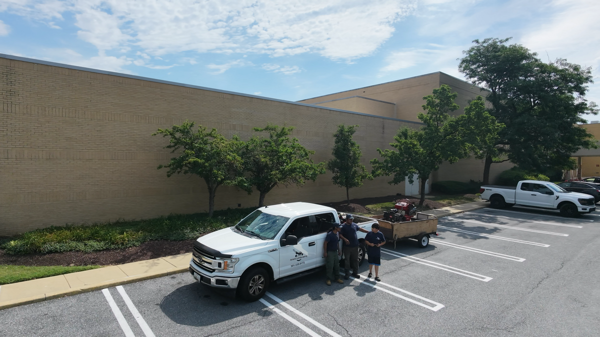 Israels Landscaping crew next to branded pick up truck and trailer.