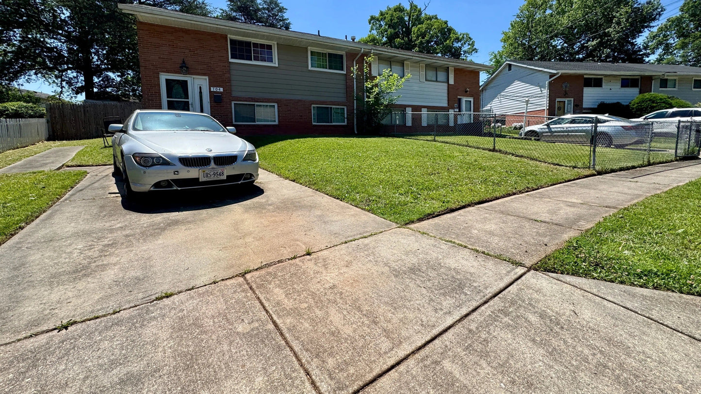 Quality lawn maintenance services Maryland showcased in a well-manicured yard with clean concrete paths